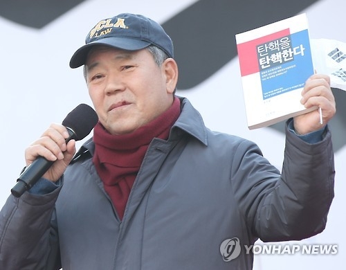 Kim Pyung-woo holds up his book, titled "I Denounce the Impeachment," at a pro-Park rally in central Seoul on Feb. 18, 2017. (Yonhap)
