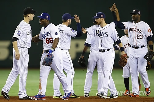 In this EPA file photo taken on Nov. 16, 2014, members of a Major League Baseball All-Star team celebrate their victory over the Japanese All-Star squad in their exhibition game at Tokyo Dome in Tokyo. (Yonhap)