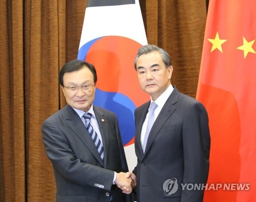 South Korean President Moon Jae-in's special envoy, Lee Hae-chan (L), shakes hands with Chinese Foreign Minister Wang Yi before having a meeting at China's Ministry of Foreign Affairs in Beijing on May 18, 2017. (Joint Press Corps)