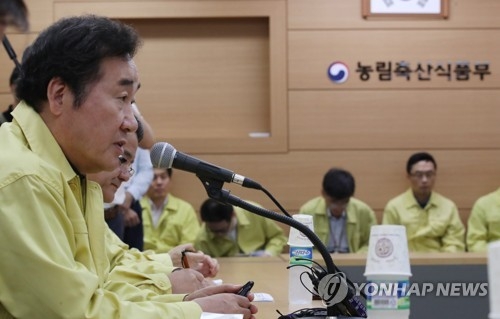 Prime Minister Lee Nak-yon (L) speaks at a meeting at the Ministry of Agriculture, Food and Rural Affairs in Sejong on Aug. 19, 2017, amid the tainted egg crisis. (Yonhap) 
