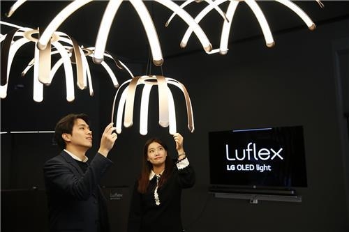 Models pose with LG Display's Luflex lighting products in this photo released by the company on Dec. 8, 2017. (Yonhap)