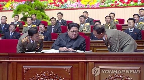 This photo captured from North Korea's Korean Central TV on Dec. 12, 2017, shows Jang Chang-ha (L) and Jon Il-ho (R) closely listening to Kim Jong-un during the 8th Conference of Munitions Industry. (For Use Only in the Republic of Korea. No Redistribution) (KCNA-Yonhap)