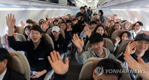 This photo, provided by the Joint Press Corps on Jan. 31, 2018, shows South Korean non-Olympic skiers waving aboard a South Korean plane bound for the North's eastern port city of Wonsan for inter-Korean ski training at a ski resort in the North. (Yonhap)
