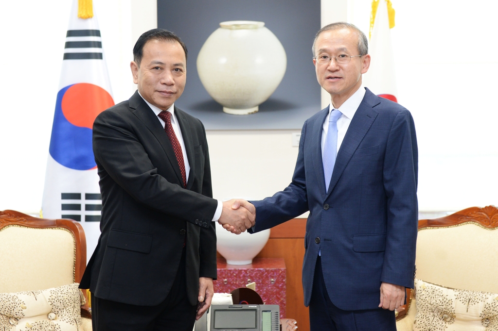 South Korean Vice Foreign Minister Lim Sung-nam (R) shakes hands with Tran Dac Loi, vice chairman of the Communist Party External Relations Commission, during a meeting in Seoul on June 15, 2018, in this photo provided by Lim's ministry. (Yonhap)