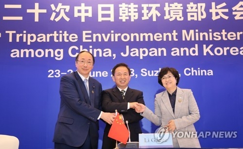 Kim Eun-kyung (R), Li Ganjie (C) and Masaharu Nakagawa, the environment ministers of South Korea, China and Japan, pose for a photo after signing a joint statement at their meeting in Suzhou, east China, on June 24, 2018, in this photo provided by Kim's office. (Yonhap)