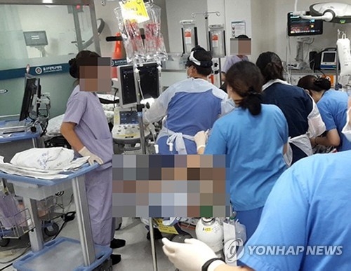 Emergency medical personnel at Ulsan University Hospital in Ulsan, 410 kilometers southeast of Seoul, tend to a Marine Corps troop injured in a helicopter crash in Pohang, just north of Ulsan, on July 17, 2018, in this photo provided by a reader. (Yonhap)
