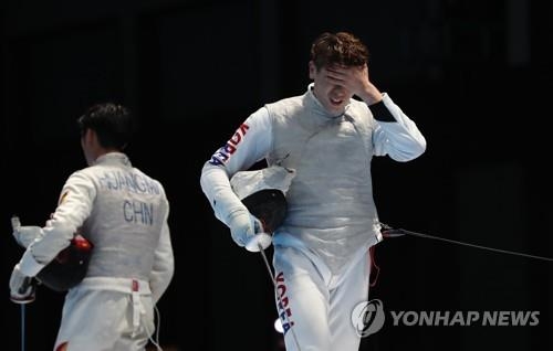 South Korean fencer Son Young-ki (R) reacts to his loss to Huang Mengkai of China in the semifinals of the men's individual foil event at the 18th Asian Games at Jakarta Convention Center (JCC) Cendrawasih Hall in Jakarta on Aug. 21, 2018. (Yonhap)