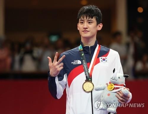 South Korean taekwondo fighter Lee Dae-hoon makes a number three sign during the medal ceremony for the men's taekwondo 68-kilogram division sparring competition at the 18th Asian Games at Jakarta Convention Center in Jakarta on Aug. 23, 2018. Lee won his third Asian Games gold medal with his lastest victory. (Yonhap)