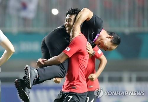 South Korean football forward Son Heung-min carries his head coach Kim Hak-bum after beating Japan 2-1 for the men's football gold medal at the 18th Asian Games at Pakansari Stadium in Cibinong, Indonesia, on Sept. 1, 2018. (Yonhap)