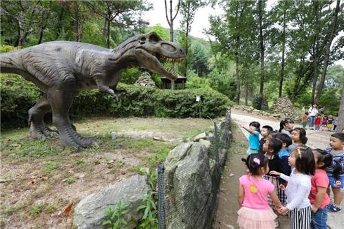 A group of children look at a dinosaur in the Dinosaur Arboretum. (Yonhap) 