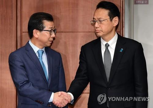 Kim Yong-kil (L), director general for Northeast Asian affairs at South Korea's Ministry of Foreign Affairs, shakes hands with his Japanese counterpart, Kenji Kanasugi, in this undated file photo. (Yonhap)