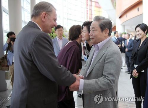 In this photo taken Aug. 28, 2011, Samsung Group Chairman Lee Kun-hee (R) shakes hands with then International Olympic Committee head Jacques Rogge at an event in Daegu, South Korea. (Yonhap)