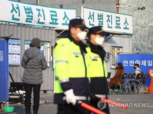 Police officers wearing masks stand guard at a medical center in Daegu, a city 300 kilometers southeast of Seoul, on Feb. 20, 2020, as people suspected of having been infected with the new coronavirus arrive to receive tests. (Yonhap)