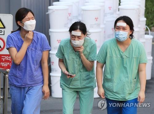 Medical staffers walk to a staff lounge after finishing a shift at Dongsan Hospital in coronavirus-hit Daegu, 302 kilometers southeast of Seoul, on March 24, 2020. (Yonhap)