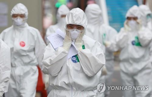 Medical workers examine their masks and other personal protective equipment before entering a hospital ward for coronavirus patients in Daegu, southeastern South Korea, on April 13, 2020. (Yonhap)