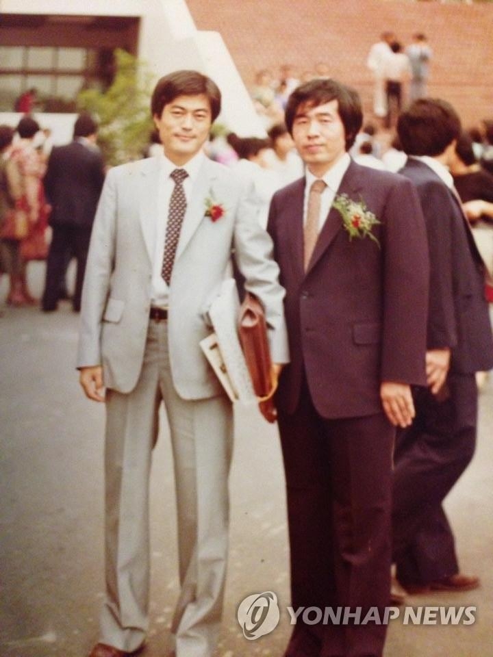 In this file photo from 1982, President Moon Jae-in (L) and late Seoul Mayor Park Won-soon pose for a commemorative photo during the graduation ceremony at the Judicial Research and Training Institute. (Yonhap)