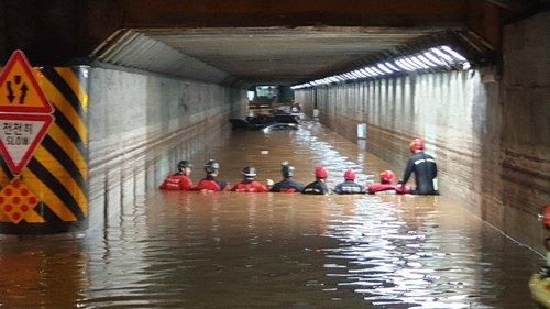 This photo, provided by the Busan Metropolitan Police Agency, shows firefighters searching an underpass submerged in rain water on July 24, 2020, after three people were found dead in their cars there the previous day. (PHOTO NOT FOR SALE) (Yonhap)