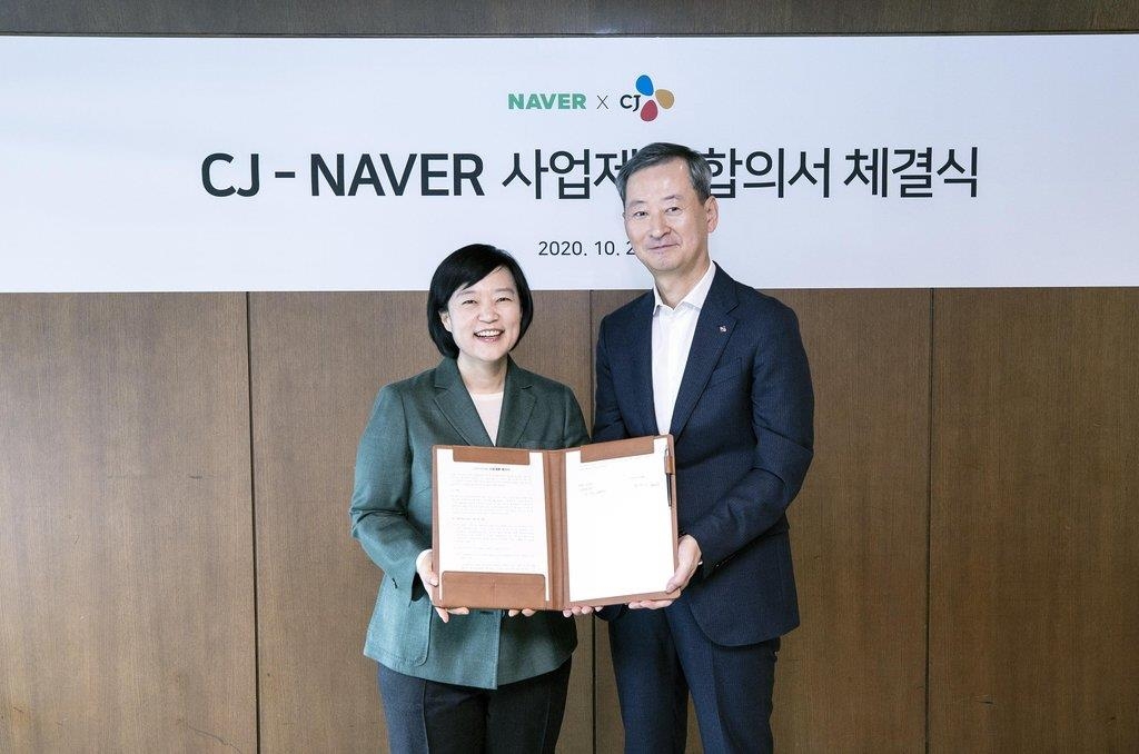 Han Seong-sook (L), CEO of Naver, and Choi Eun-seok, head of Management Strategy Office of CJ Corp., pose after signing a strategic partnership deal on Oct. 26, 2020, in this photo provided by Naver. (PHOTO NOT FOR SALE) (Yonhap)