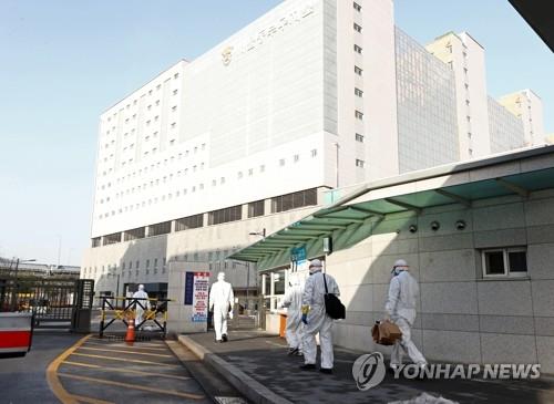 Medical workers walk in front of the entrance of Dongbu Detention Center in Seoul on Jan. 14, 2021. (Yonhap)