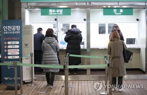 In this file photo, people apply for COVID-19 tests at a testing station set up for departing passengers at the second terminal of Incheon International Airport, west of Seoul, on Jan. 8, 2021. (Yonhap)