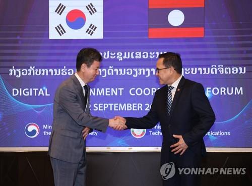 This file photo, provided by South Korea's interior ministry on Sept. 2, 2022, shows South Korean and Lao officials shaking hands ahead of a digital government cooperation forum held in Vientiane. (PHOTO NOT FOR SALE) (Yonhap)