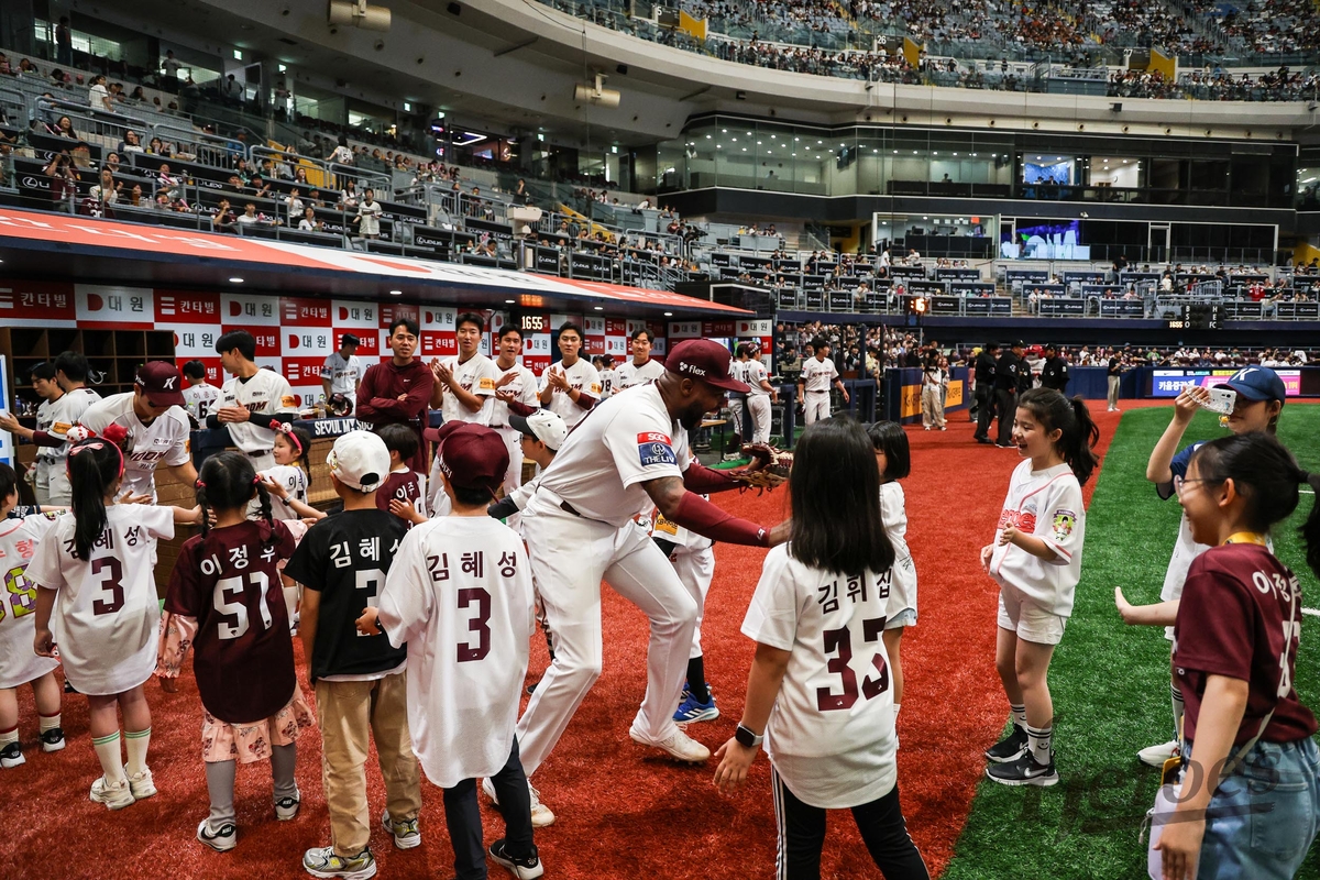 Ronnie Dawson of the Kiwoom Heroes (C) high-fives children during the pregame player introduction before a Korea Baseball Organization regular-season game against the SSG Landers at Gocheok Sky Dome in Seoul on May 18, 2024, in this photo provided by the Heroes. (PHOTO NOT FOR SALE) (Yonhap) 