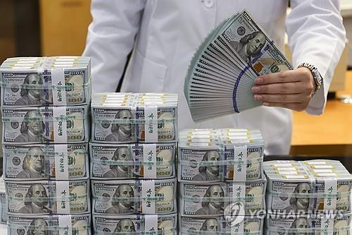 An official checks banknotes at a Hana Bank branch in Seoul, in this May 7, 2024, file photo. (Yonhap)