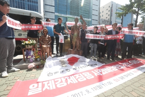 少女像のそばに設置された労働者像のレプリカ＝１８日、釜山（聯合ニュース）