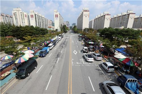 광주 상무지구 금요시장 노점이 옮겨갈 예정인 상무시민공원 일원. 왕복 6차로 도로 양쪽에서 기존에 이주한 노점이 9일 좌판을 열고 있다.