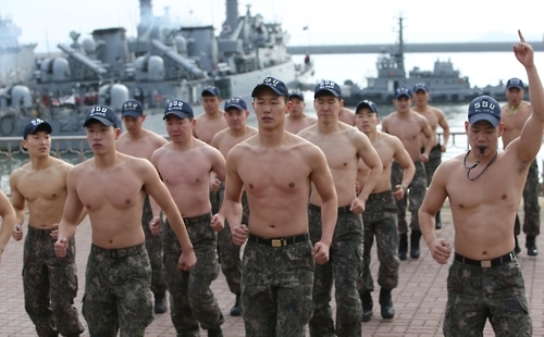2함대 SSU 대원들이 맨몸구보로 혹한기 훈련을 하고 있다. 뒤에는해군 초계함이 정박해 있다.