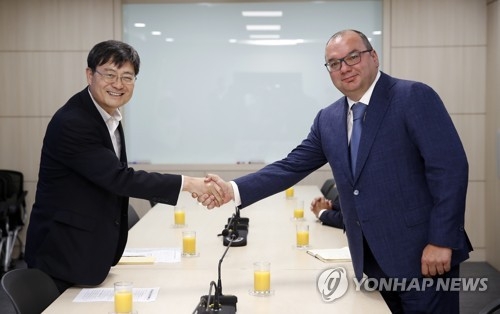 악수하는 송수근 직무대행과 미하일로프 타스 사장