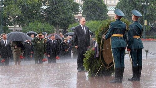 블라디미르 푸틴 러시아 대통령(앞쪽)이 나치 독일 침공 76주년인 22일(현지시간) 크렘린궁옆 무명용사의 묘에서 폭우를 맞으며 헌화행사에 참석하고 있다. [타스=연합뉴스]