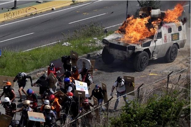 베네수엘라 수도 카라카스에서 시위대의 공격으로 경찰 차량이 불에 타고 있다.[브라질 일간지 폴랴 지 상파울루] 