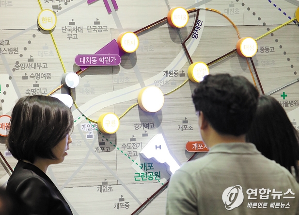 모델하우스 벽에 마련된 대형 지도를 보며 입지를 파악하는 방문객들. 이상학 연합뉴스 기자