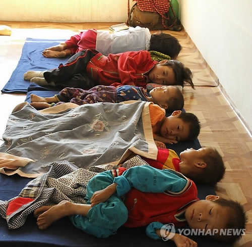 나란히 누워 있는 지친 표정의 북한 어린이들(로스앤젤레스=연합뉴스) 수해 피해를 당한 북한의 한 지역 병원에 영양실조에 걸린 북한 어린이들이 나란히 누워 있다. 이 사진은 '머시코' 등 미국의 5개 구호 단체 대표들이 지난 9월4일부터 10일까지 북한을 방문했을 때 찍은 것이다. 2011.10.2khoon@yna.co.kr(끝)