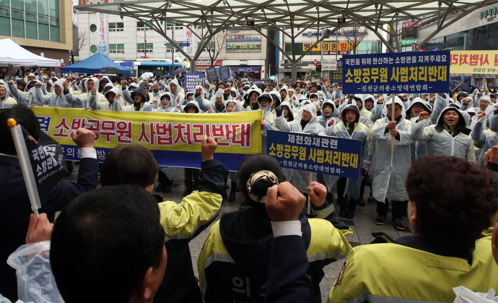 충북의용소방대 회원들이 19일 오전 제천시민회관 광장에 모여 소방관 처벌 반대 집회를 열고 있다. 