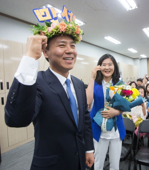 '만세'란 단어가 새겨진 월계관을 머리에 쓴 김승수 당선인