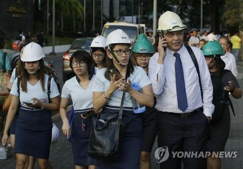 강진에 안전모를 쓴 마닐라 시민들