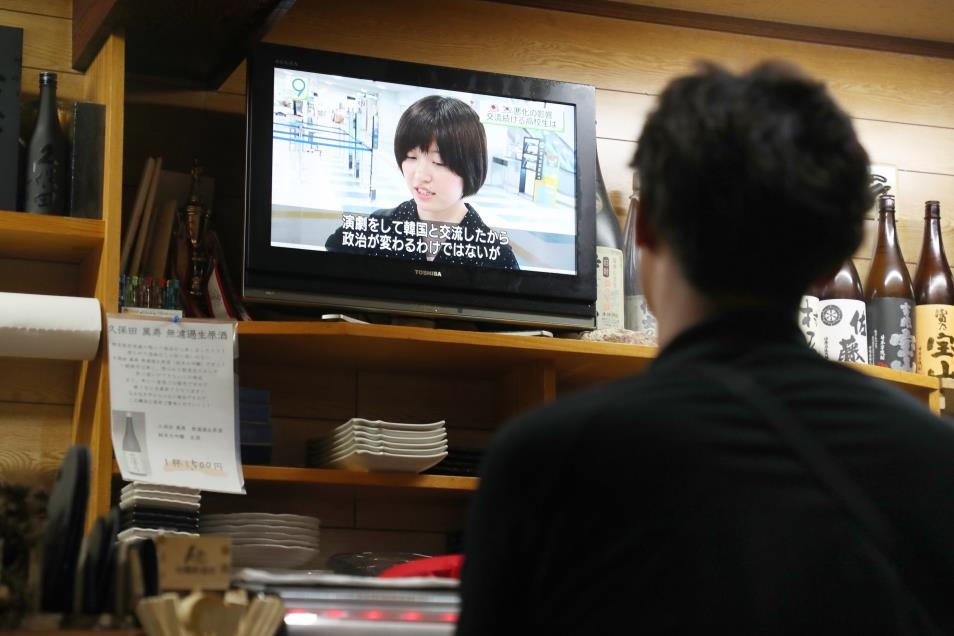 8일 밤 한 이자카야에서 일본인이 한일 청년 민간교류 뉴스를 시청하고 있다.