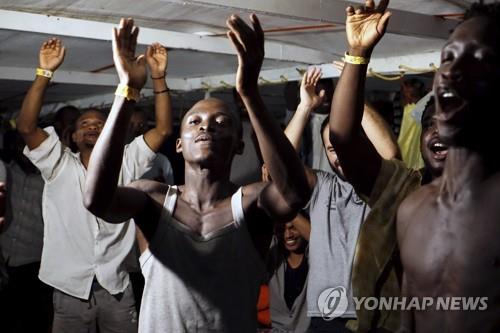 20일(현지시간) 이탈리아 검찰이 자신들이 탄 난민구조선 '오픈 암즈'의 정박을 허용했다는 소식에 난민들이 환호하고 있다.[AP=연합뉴스]