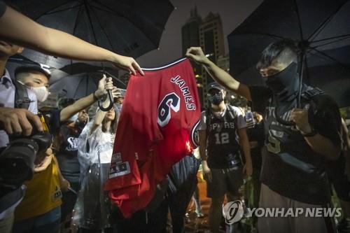 홍콩시위대가 NBA 스타인 르브론 제임스의 이름이 새겨진 운동복을 들고 있다. 