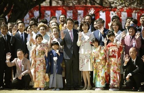 아베 신조 총리가 올 4월 13일 도쿄 도심 공원인 '신주쿠 교엔'에서 열린 '벚꽃을 보는 모임' 행사에서 참석자들과 기념사진을 찍고 있다. [교도=연합뉴스 자료사진]