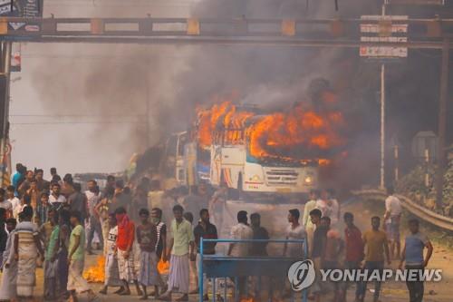 14일 인도 웨스트벵골주 콜카타 인근에서 길을 막고 버스를 불태우는 시민권법 개정 반대 시위대. [AFP=연합뉴스]