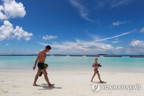 몰디브의 한 해변을 걷고 있는 관광객들 [로이터=연합뉴스] 