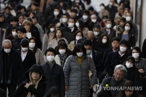 (도쿄 AP=연합뉴스) 지난 18일 일본 도쿄의 직장인들이 대거 마스크를 착용하고 인도를 걸어가고 있다. 