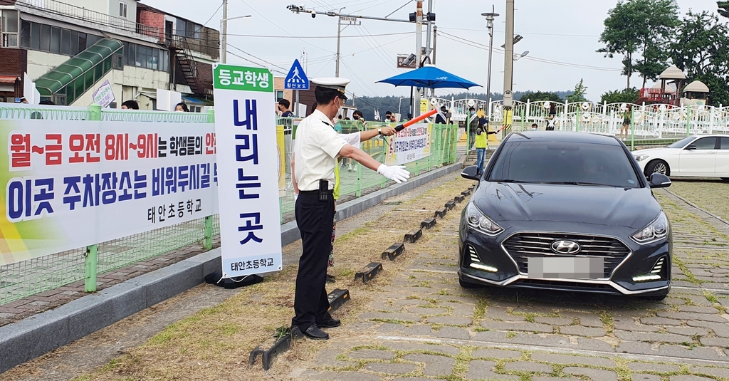 태안초등학교 앞 주차장에서 차량 안내하는 경찰관