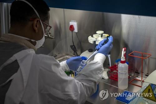 지난 5월 21일 한 남아공 연구소 기술자가 코로나19 검체 샘플을 처리하고 있다.