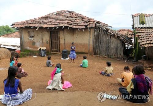 코로나19 사태로 학교가 문을 닫은 뒤 온라인 수업조차 받을 수 없는 인도 마하라슈트라주의 아이들이 흙바닥에 앉아 과외로 마련된 수업에 참여하고 있다. [로이터=연합뉴스]