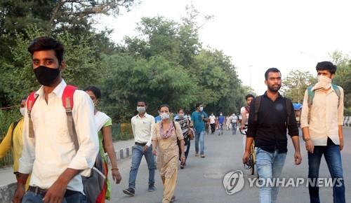인도 뉴델리에서 마스크를 쓰고 이동하는 시민. [EPA=연합뉴스]