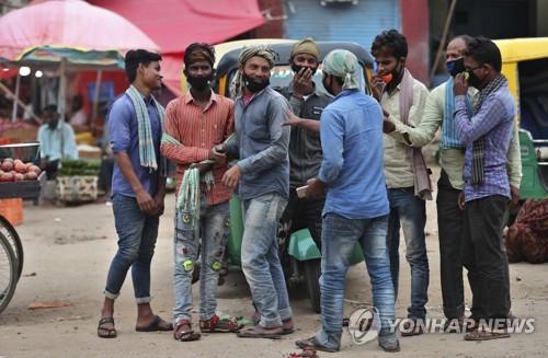 인도 벵갈루루의 도매시장에서 이야기를 나누는 인부. 일부는 마스크를 제대로 착용하지 않았다. [AP=연합뉴스]